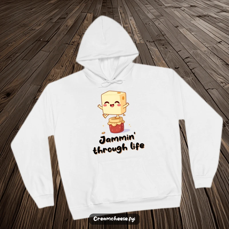 Funny hoodie illustrating a happy cream cheese block in mid-air, leaping over a small jam jar, conveying energy and playful spirit.